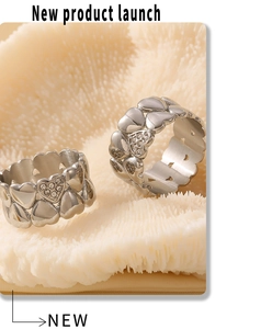 Macro shot of silver vintage heart rings with sparkling crystals on coral texture