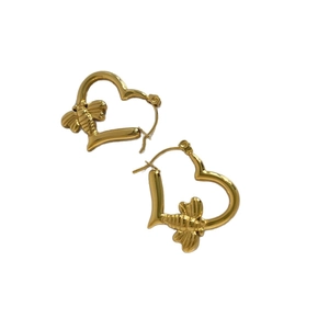 Golden heart earrings with detailed bee charms made of stainless steel on white background