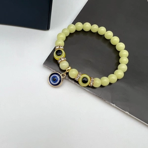 Luminous Evil Eye beaded bracelet with yellow glow-in-the-dark stones and blue charms