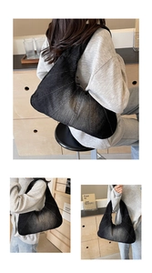Détail du sac hobo en jean noir délavé avec coutures radiales et large bandoulière