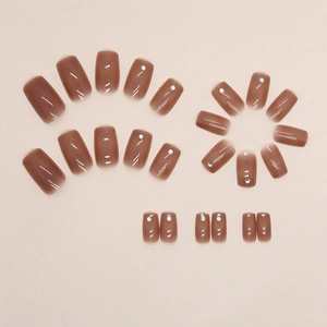 Glossy amber coffee square press-on nails set with micro rhinestones on beige background