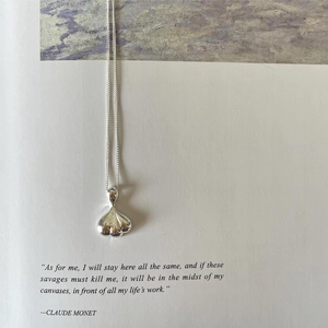 Artistic detail of a polished silver garlic pendant on an elegant book background