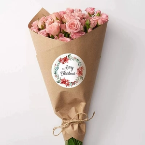 Round Merry Christmas sticker with floral wreath on craft paper gift wrap