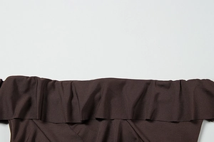 Detailed view of the dark brown off-shoulder ruffle neckline and stitched fabric texture