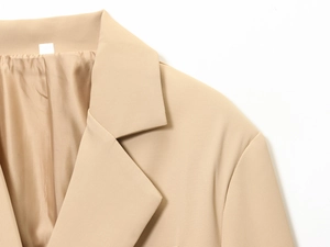 Detailed close-up of khaki blazer lapel and shoulder stitching on twill fabric