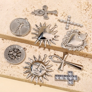 Flat lay of diverse stainless steel pendants including Viking crosses and sun charms