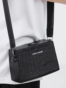 Classic black crocodile pattern box bag with wide strap and metal lock shown on model