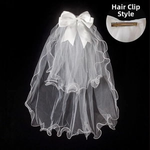 Detail of short white bridal veil with satin bow and secure metal hair clip attachment