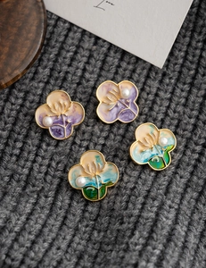 Macro detail of oil painting style clover earrings with natural pearls and gold edges