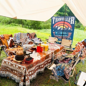 Close-up of woven bohemian camping blanket with ethnic patterns and decorative tassels