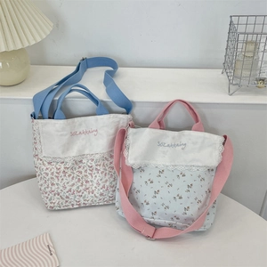 Detail of floral canvas tote bags with delicate lace trim and custom embroidery