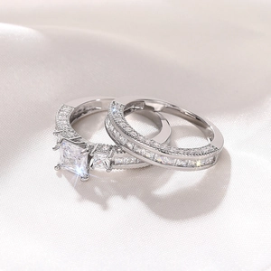 Macro-opname van diamanten ringen met prinsessenslijpsel op wit satijnen stof