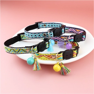 Detail of checkered cat collars with bells, tassels and cat-shaped plastic buckles