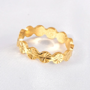 Golden sunburst pattern titanium steel ring on white textured fabric background