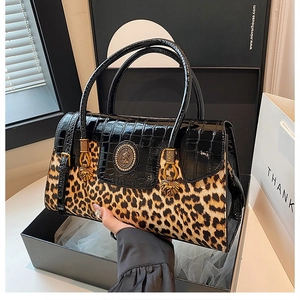 Close-up of leopard print and crocodile texture handbag in a premium gift box