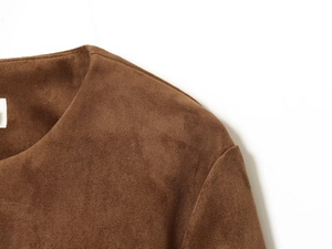 Gros plan de la couture d'épaule sur un blazer en daim marron avec texture mate et détails