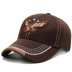 Brown baseball cap with eagle embroidery and white contrast stitching on a white background