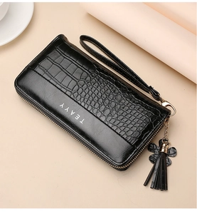 Detail of black crocodile-embossed leather long wallet with tassel and wristlet strap