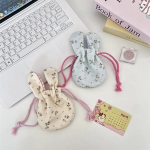 Close-up of cute floral bunny ear drawstring bags in light blue and cream colors