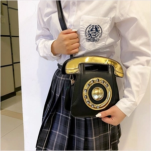 Retro telephone shaped shoulder bag in black PU leather with sequined dial shown on model