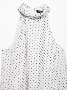Detailed close-up of white chiffon halter top with black polka dots and Index inner neck label