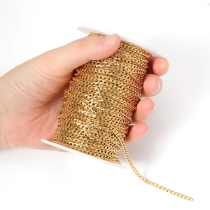 Hand holding a spool of golden stainless steel Cuban link chain for DIY jewelry making