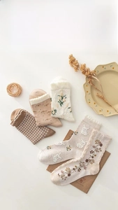 Flat lay of five cotton crew socks with floral and plaid patterns for autumn and winter