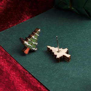 Detailed view of festive Christmas tree wooden stud earrings with snowflake patterns