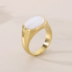 Detail of a square gold stainless steel ring featuring a white oval shell inlay