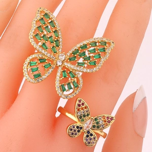Elegant gold butterfly rings set with green and colorful rhinestones on hand model