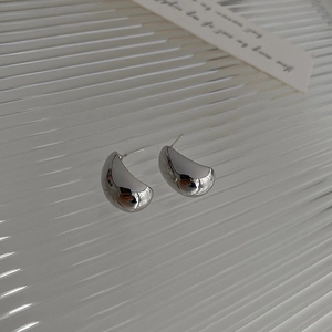 Macro shot of silver-colored layered circular earrings with smooth metallic finish
