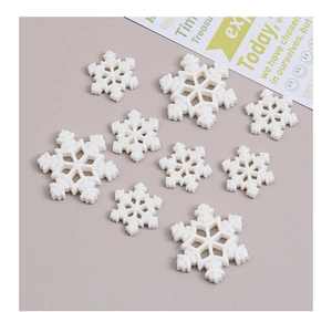 Flat lay of white glitter resin snowflakes in three sizes for DIY craft decorations