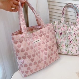 Close-up of pink heart jacquard fabric and brand label on a stylish tote bag