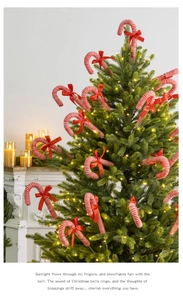 Detail of red and white striped candy cane ornament with a red bow on a Christmas tree