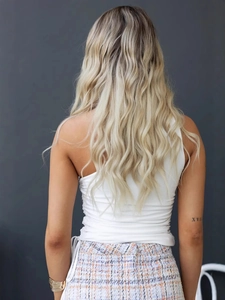Vue de dos d'une femme portant un haut blanc cintré à une épaule et un short en tweed