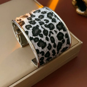 Detailed close-up of a wide leopard print bangle with faux fur finish and silver metal edges