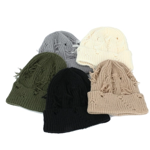 Detailed view of distressed knit beanies with ripped holes in various trendy colors