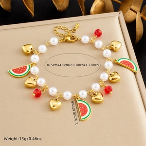 Detail view of pearl chain bracelet featuring a watermelon pendant and gold heart charm