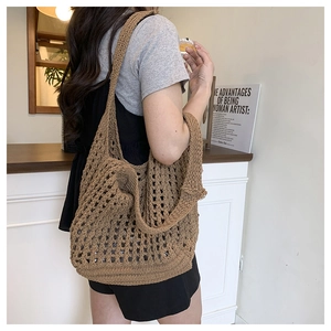 Close-up of brown hollow knit tote bag with intricate floral weave and thick texture