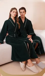 Detail of dark green plush long bathrobe with white contrast trim for winter warmth