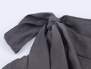 Detail of the dark gray woven fabric shirt showing the knot and bow tie craftsmanship