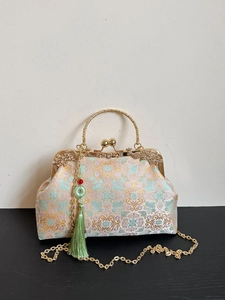 Embroidered floral frame bag with metal handle, green tassel and chain strap in neo-retro style