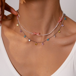 Detail of double-layer beaded necklace with pink silk bow and colorful crystal charms