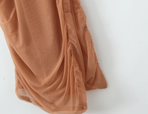 Vue rapprochée des couches de maille marron rouille et des coutures sur la robe