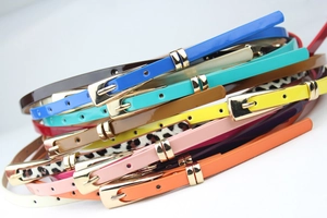 Close-up of colorful skinny belts with shiny finish and square golden metal buckles