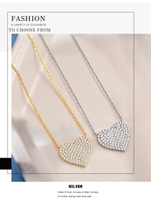 Detailed view of silver and gold heart pendants with shimmering pavé crystal settings