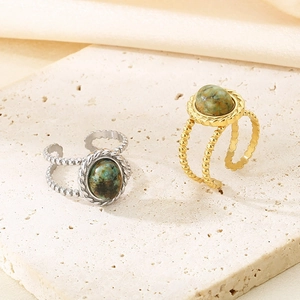 Macro detail of vintage gold and silver open rings with green stone on stone base