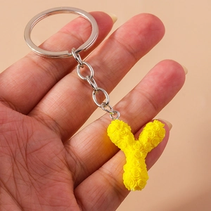 Detail of yellow rose-patterned letter Y keychain with silver metal ring and chain