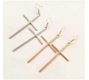 Detail of long punk cross drop earrings in gold and silver finish with hook clasp