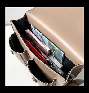 Close-up showing internal multi-layer storage compartments of khaki messenger bag